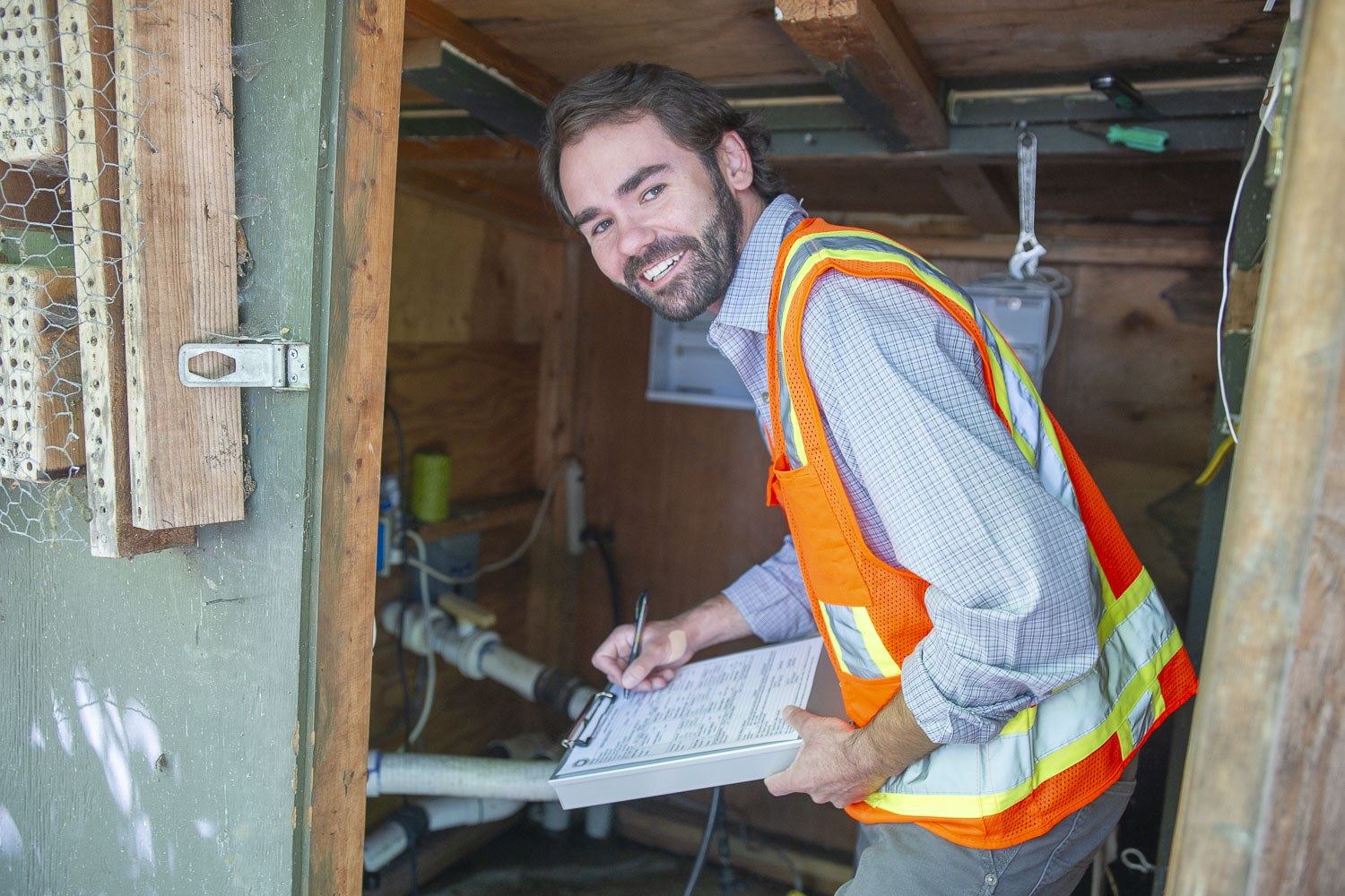 Technician filling out a test report in a crawlspace